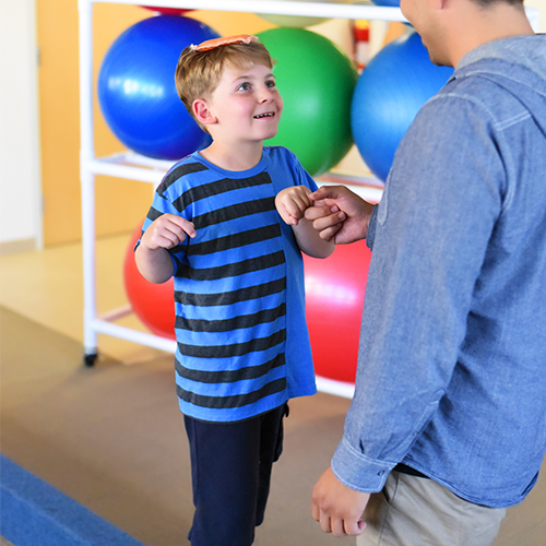 Pediatric patient working on balance with therapist